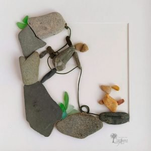 Cuadro de decoración con piedras hecho a mano en Barcelona con piedras de montaña, guijarros, cristales del mar chico escalando con Fiona su fiel perra UdanasArt
