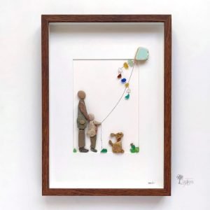 Cuadro de decoración con piedras hecho a mano en Barcelona con piedras guijarros azulejos padre e hijo volando una cometa azul Arte con piedras la cometa azul UdanasArt